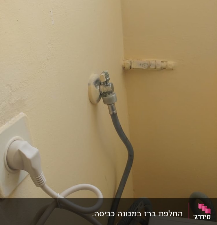 ברז מים מחובר לצינור גומי על קיר